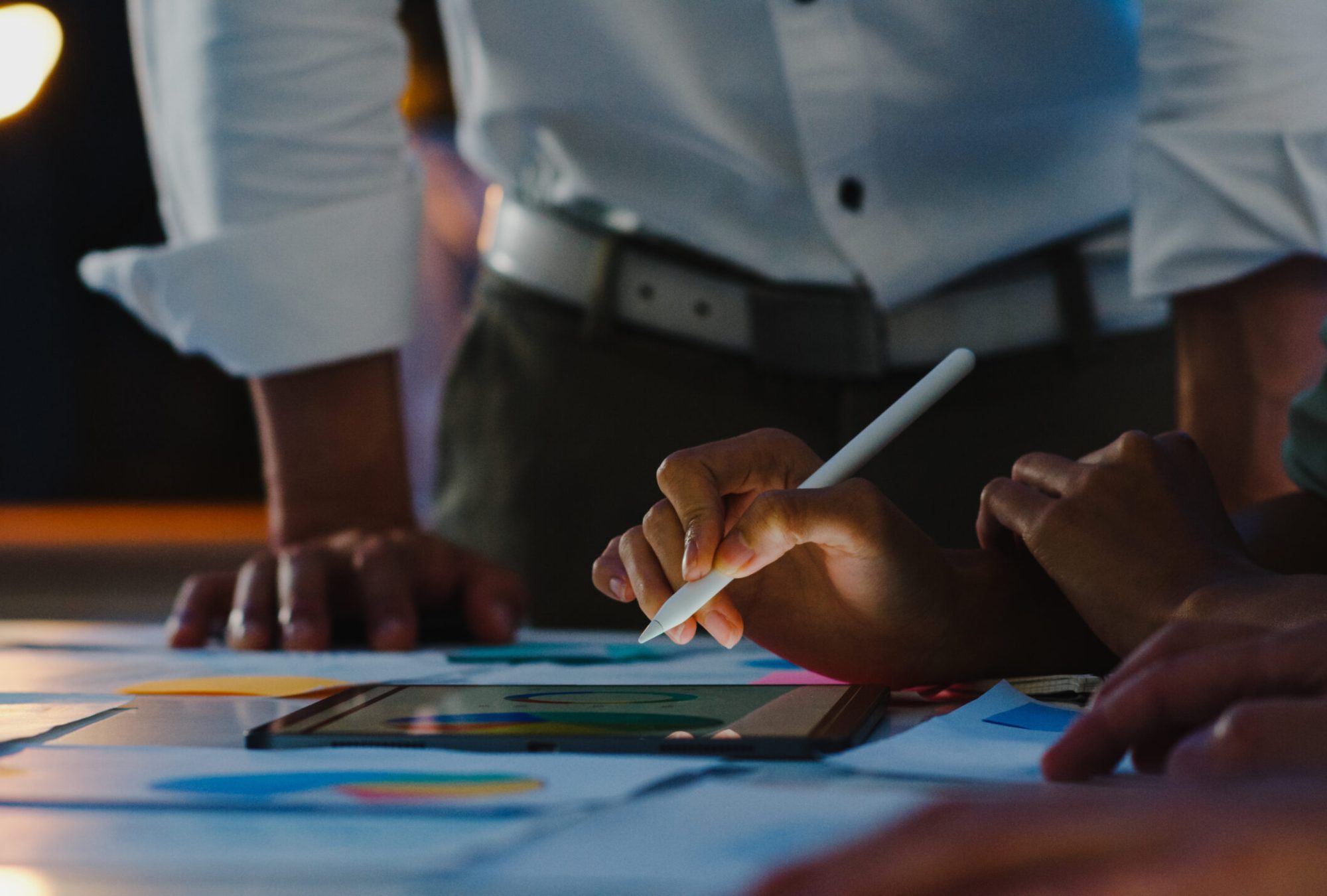 Group of Asia young creative people in smart casual wear discussing business brainstorming meeting ideas mobile application software design project in modern night office. Coworker teamwork concept.